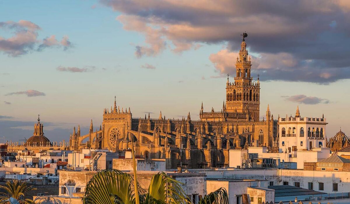 Catedral de Sevilla al atardecer bajo una luz anaranjada, escenario perfecto para una boda en Sevilla.