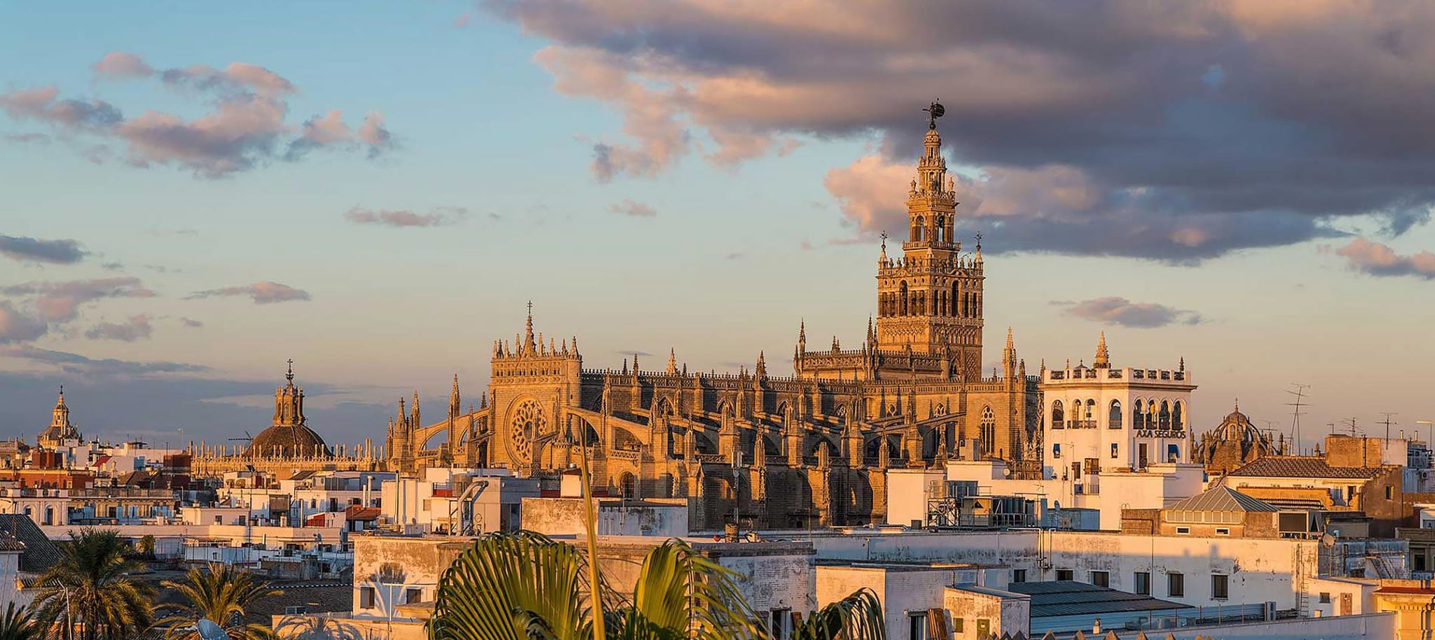 Catedral de Sevilla al atardecer bajo una luz anaranjada, escenario perfecto para una boda en Sevilla.