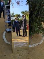 Invitados de boda en Sevilla reflejados en un espejo de bienvenida personalizado con vinilo "Luces, cámara, acción" durante el cóctel al aire libre, un detalle que marca la diferencia. Creado por Serendipia Weddings.